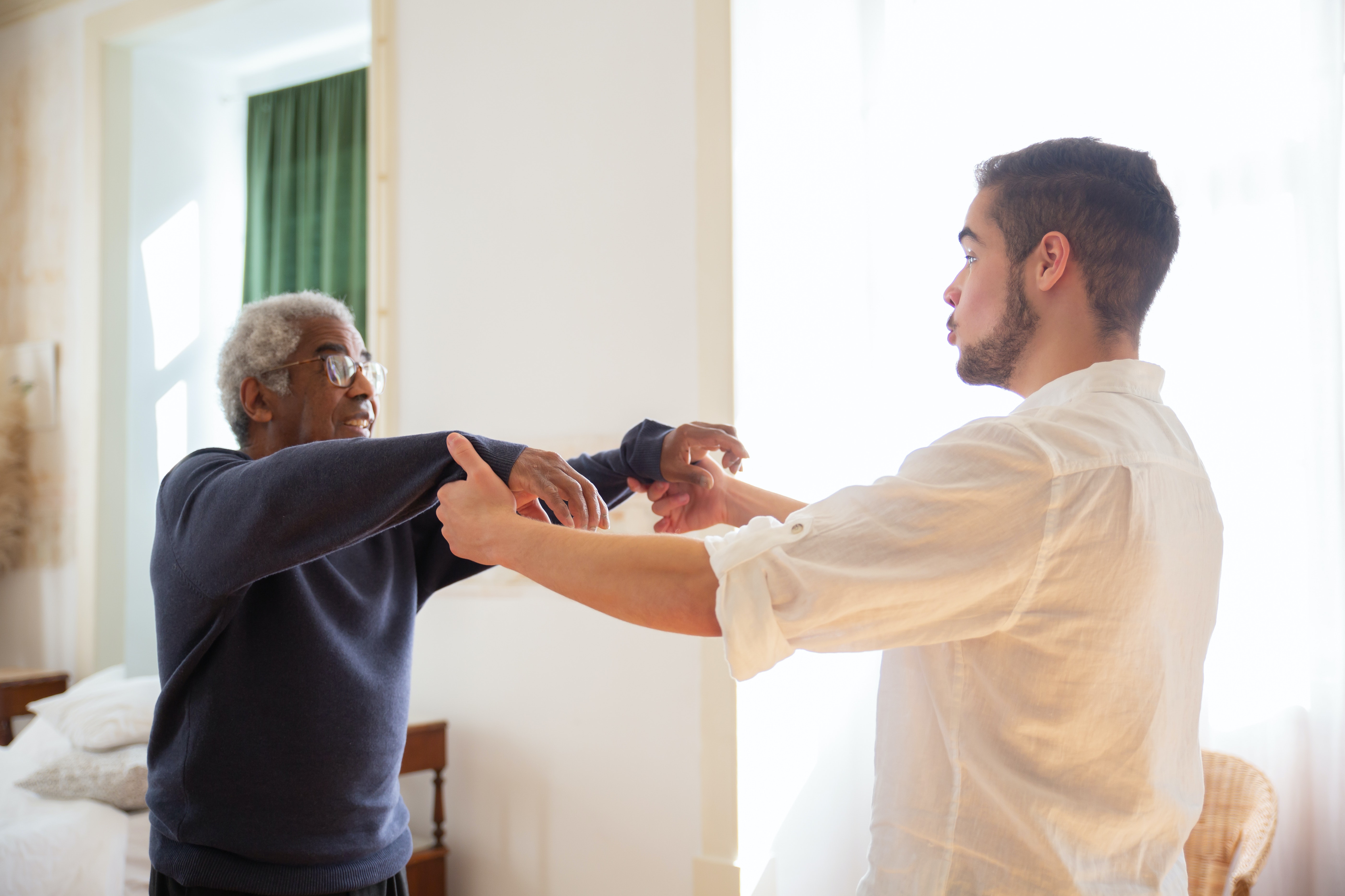 Elderly man dancing with younger man