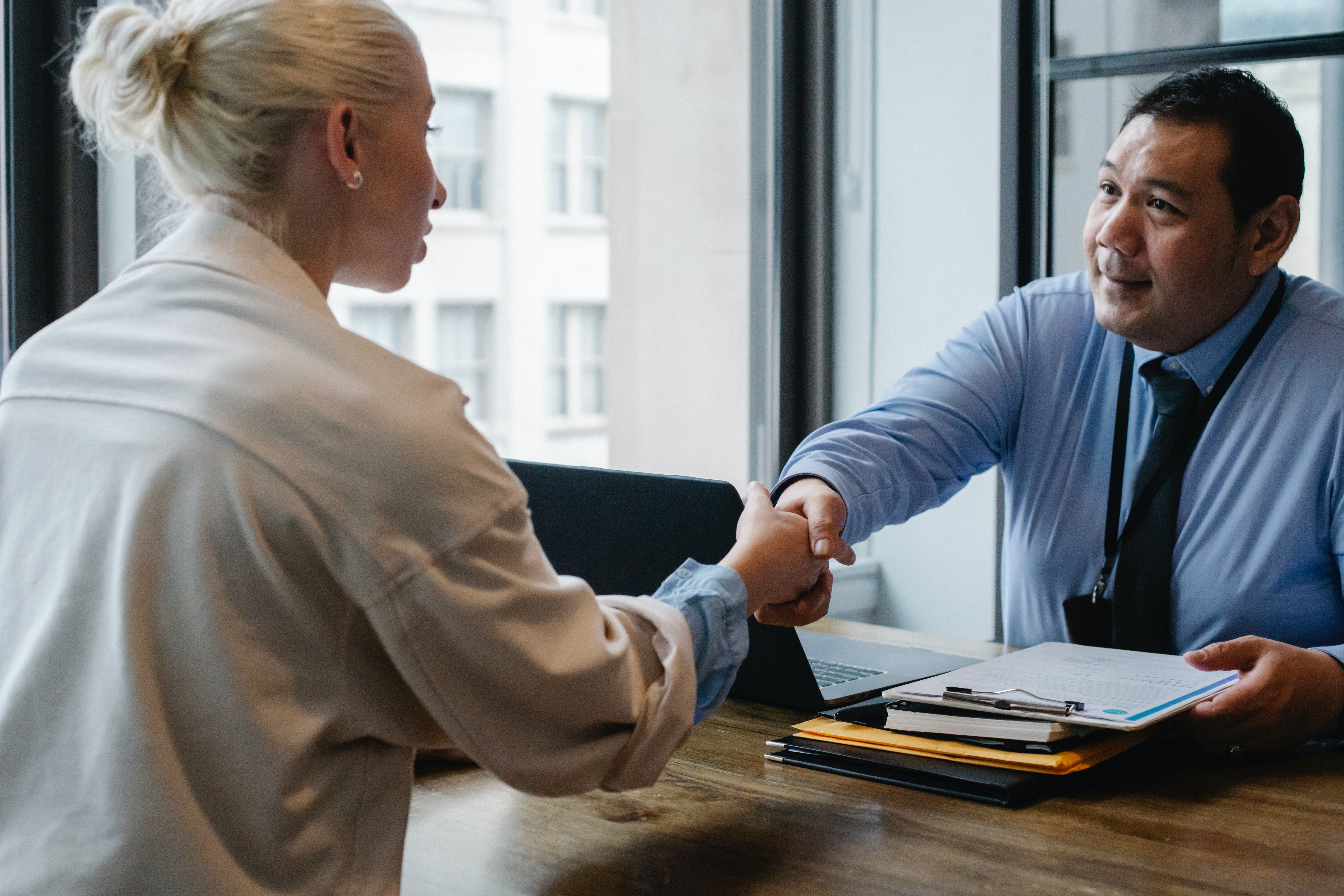 Man and woman shaking hands over a desk