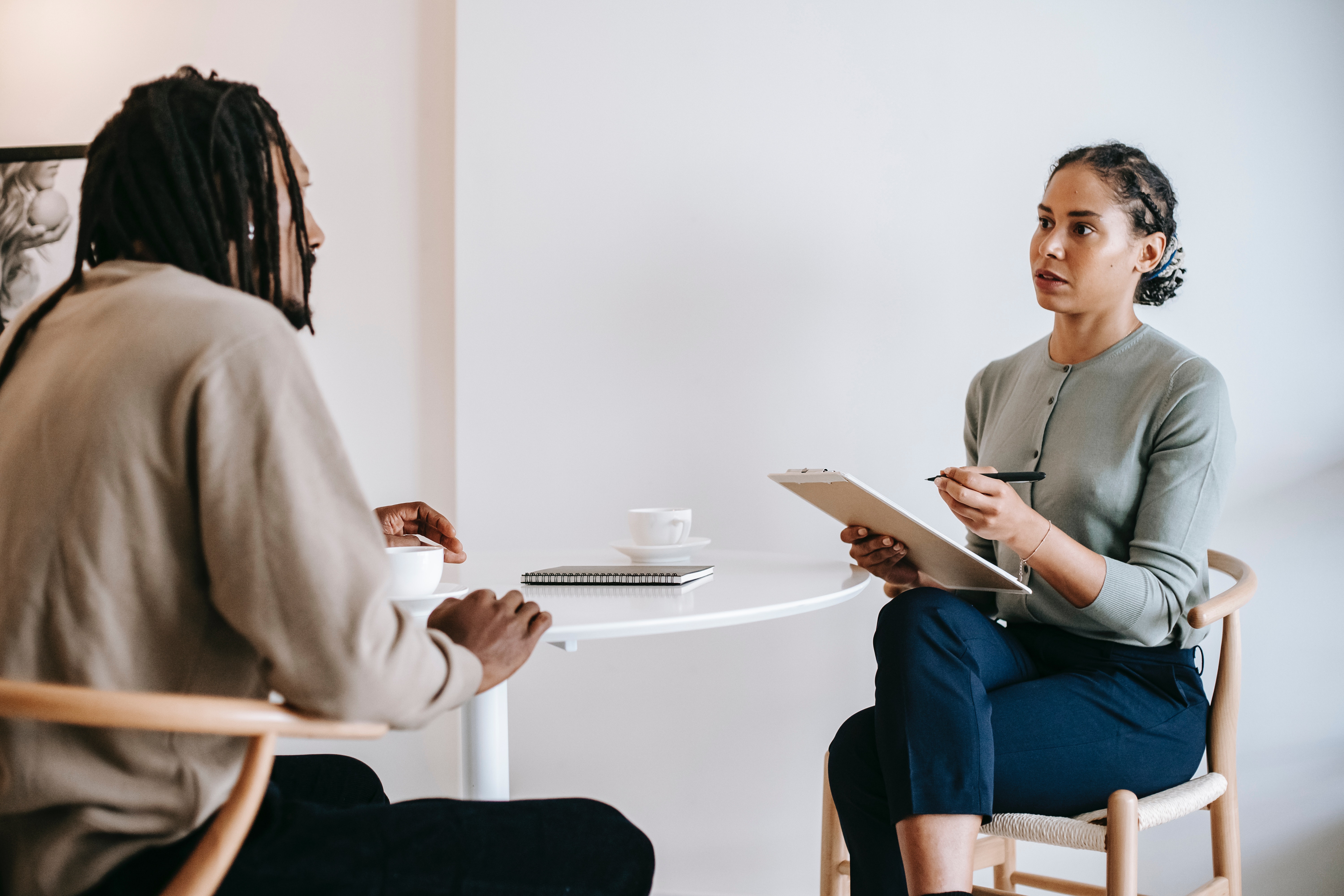 Woman holding a clipboard interviewing a man