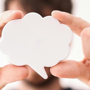 A stock photo from Pexels depicting a man holding up a speech bubble