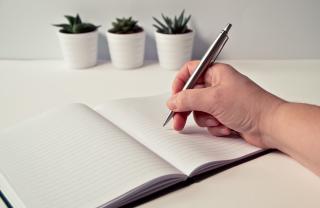 A stock photo of someone starting to make plans using a notebook