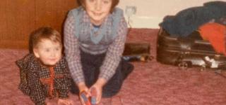 Old photo of Ruth and her brother as children with a trainset