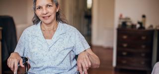 Woman in a wheelchair smiling and looking at the camera