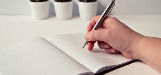A stock photo of someone starting to make plans using a notebook