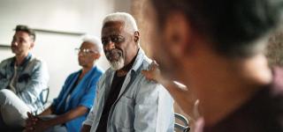 A man being comforted in a group of people