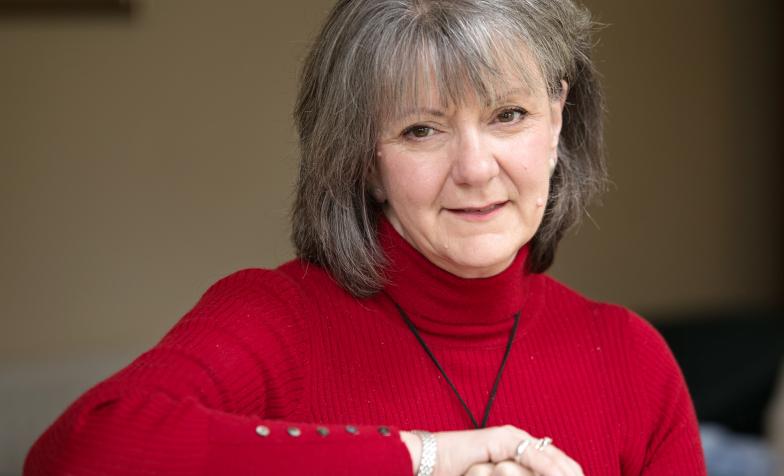 Carole Walford in red jumper, landscape headshot