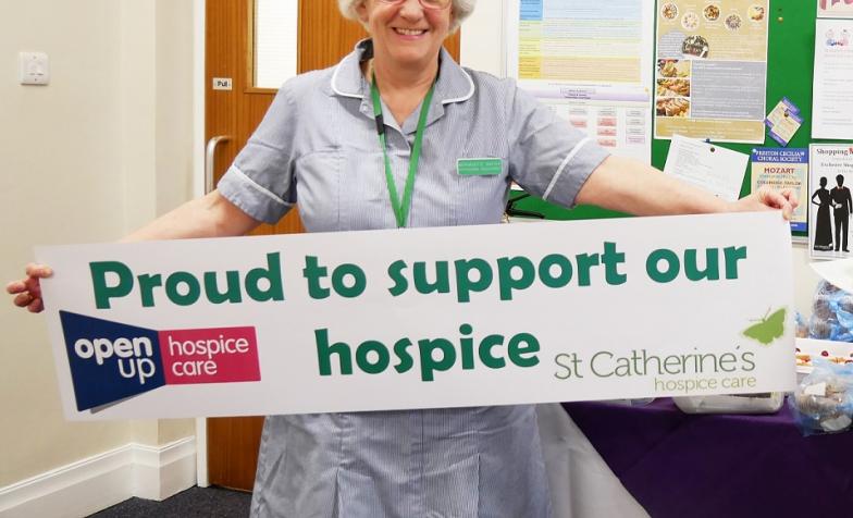 3 decades of hospice care, Bernadette Baxter holding a banner