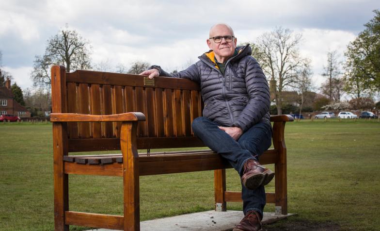 David sitting on a bench dedicated to his father