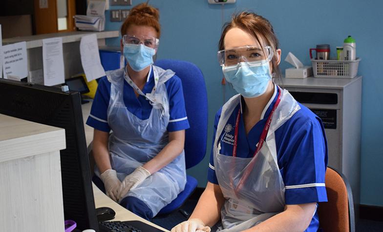 Two hospice care staff at Trinity Hospice in Blackpool carrying out their work wearing PPE
