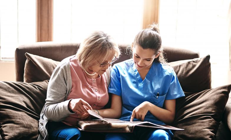 Nurse looks through photo album with patient