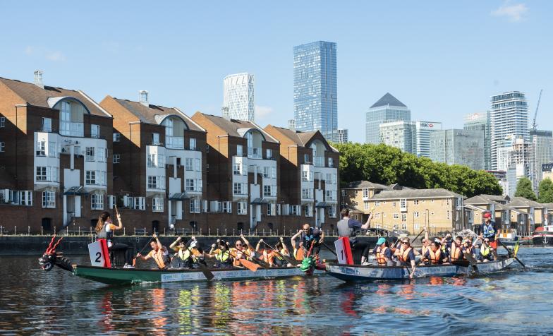 Two dragon boat teams on the water in Canary Wharf