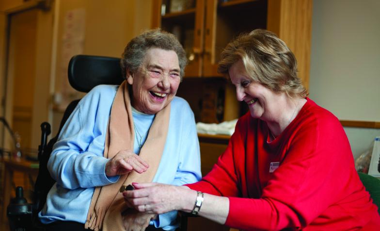 Older woman with in wheelchair with nurse