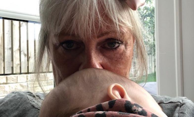 a woman with blonde hair kisses a baby's head