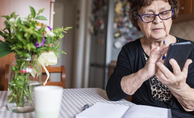 Older woman using smartphone with glasses on