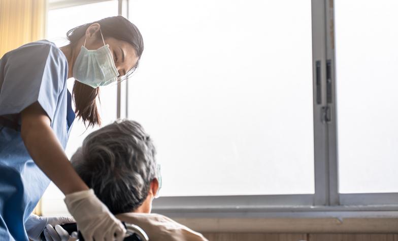 Nurse talking to patient in wheelchair