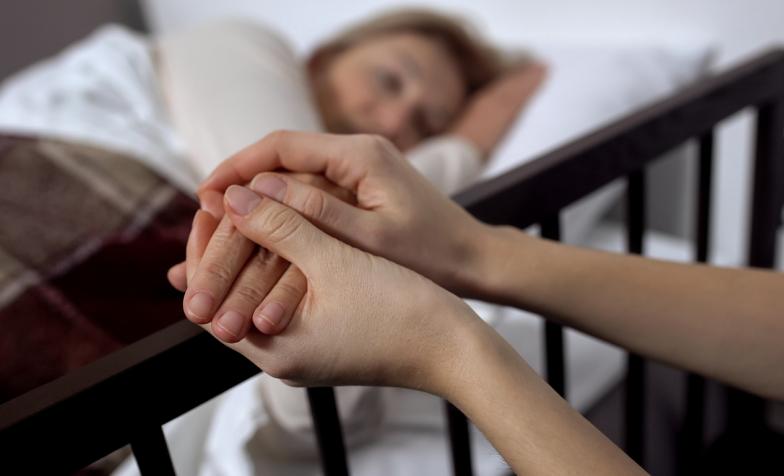 Older female patient holding hands