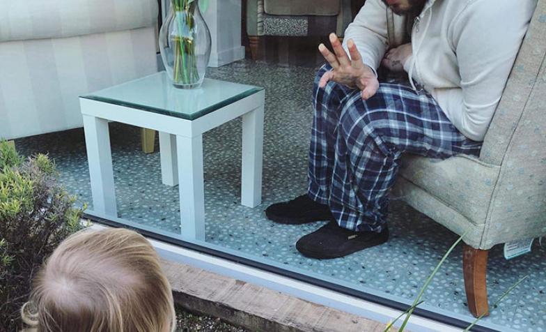 Tom, waving to his daughter Poppy at St Luke's Hospice in Plymouth