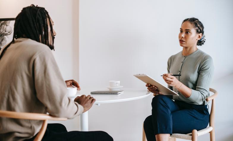 Woman holding a clipboard interviewing a man