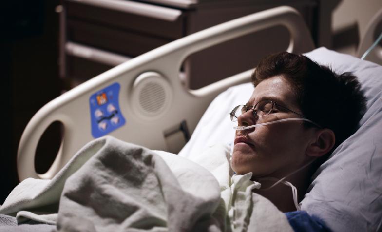 Patient in hospital bed wearing a nasal canula