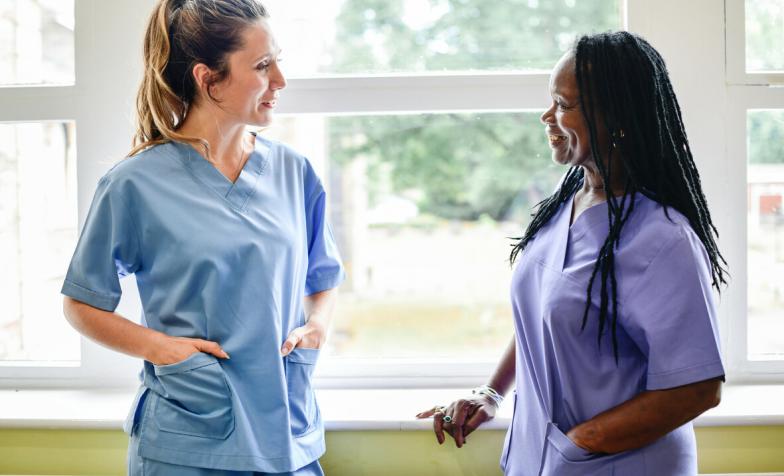 two nurses talking in a hospital hallway