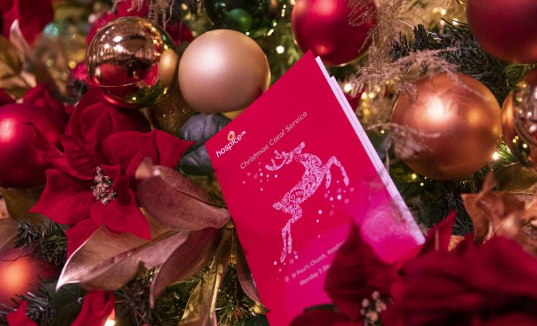 Red programme nestled in a christmas tree, decorated with baubles