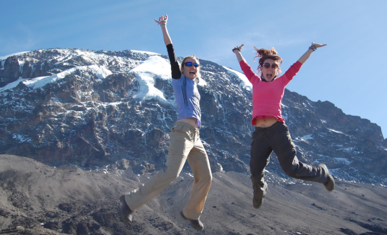 walkers jumping with joy in front on Kilimanjaro
