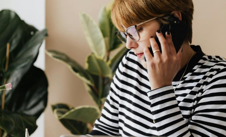 women speaking on phone with laptop