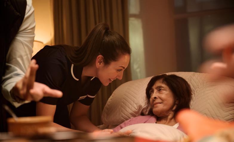 From This is Hospice Care legacy campaign - woman in bed at her home with hospice nurse by her side