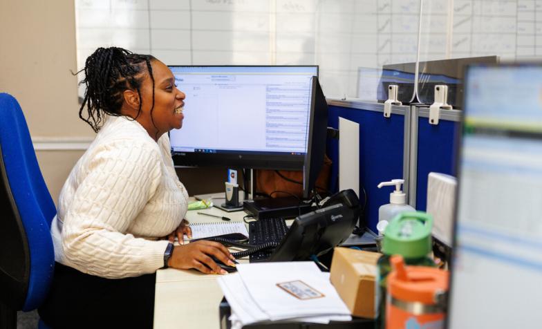 A woman smiling working at a computer