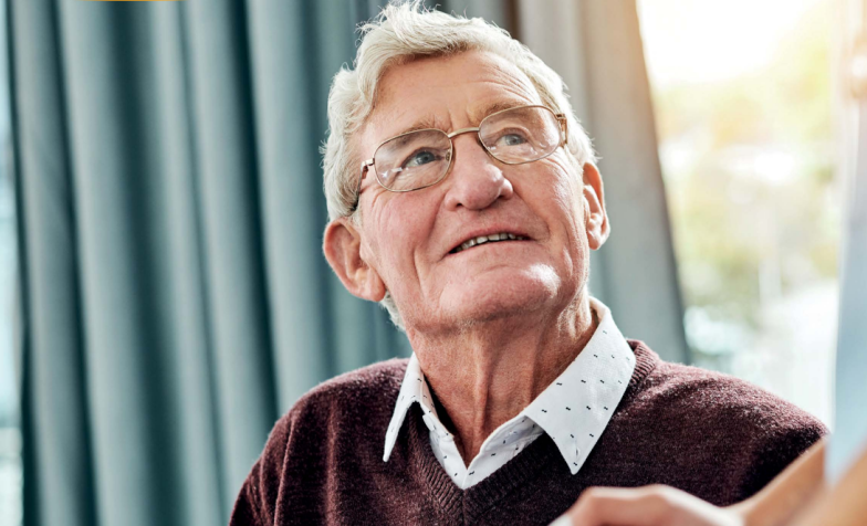 An elderly man looks up at someone out of frame.