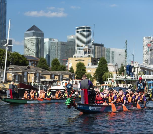 Two dragon boat teams on the water in Canary Wharf