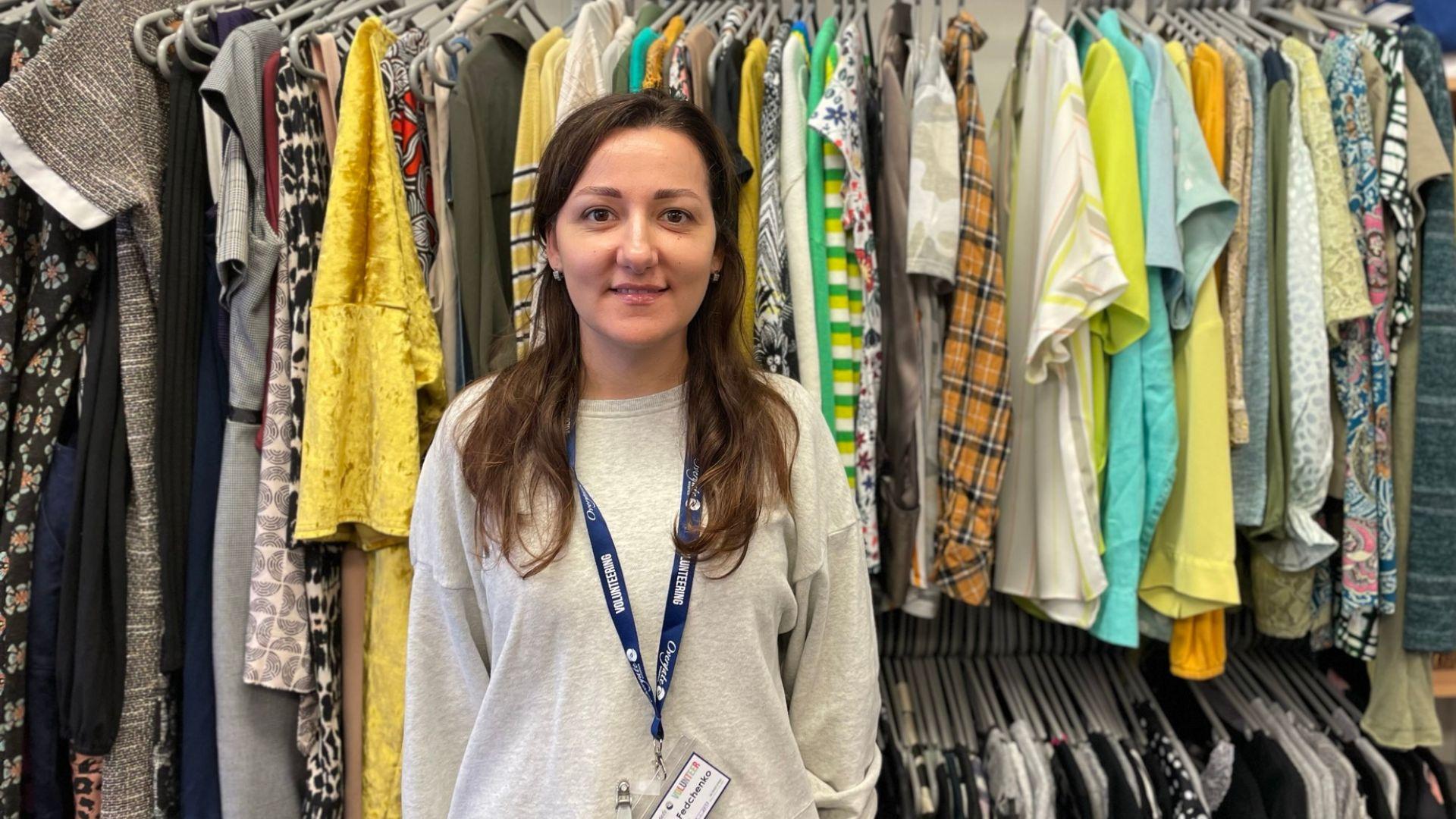 Ukrainian female volunteer standing in front of a clothing rail