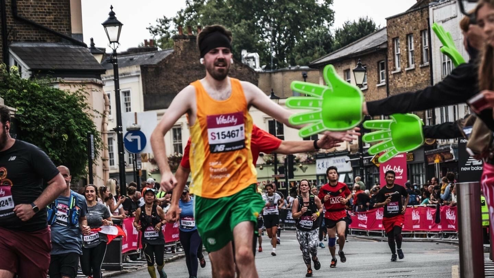 Man wearing orange vest running in a marathon