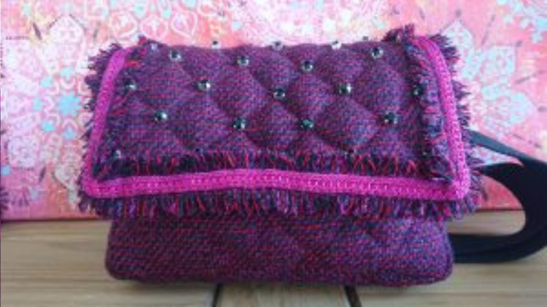 A purple handbag made from wool
