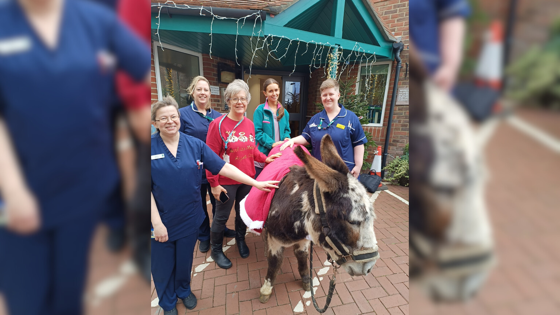 Patients standing in front of a hospice with a donkey