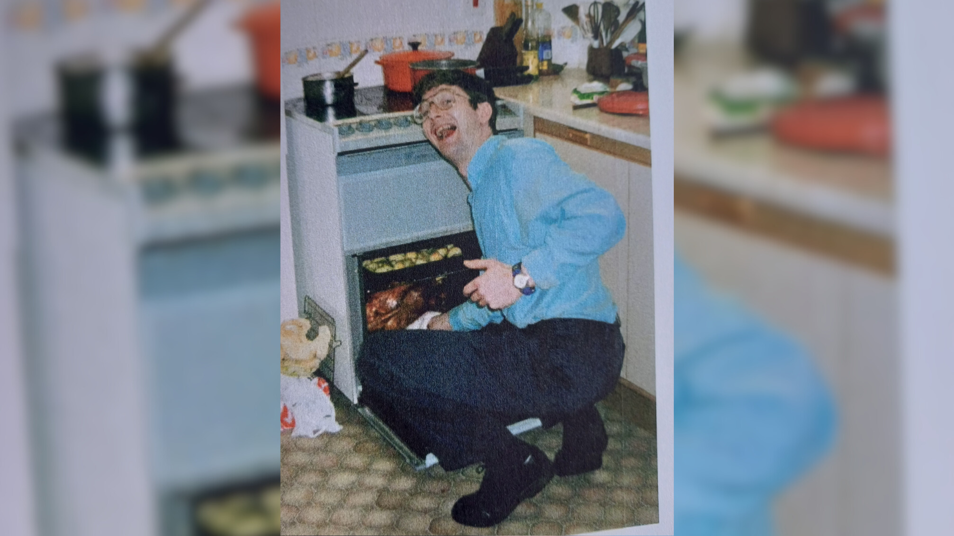 An old photo of a man crouched at the oven on Christmas day