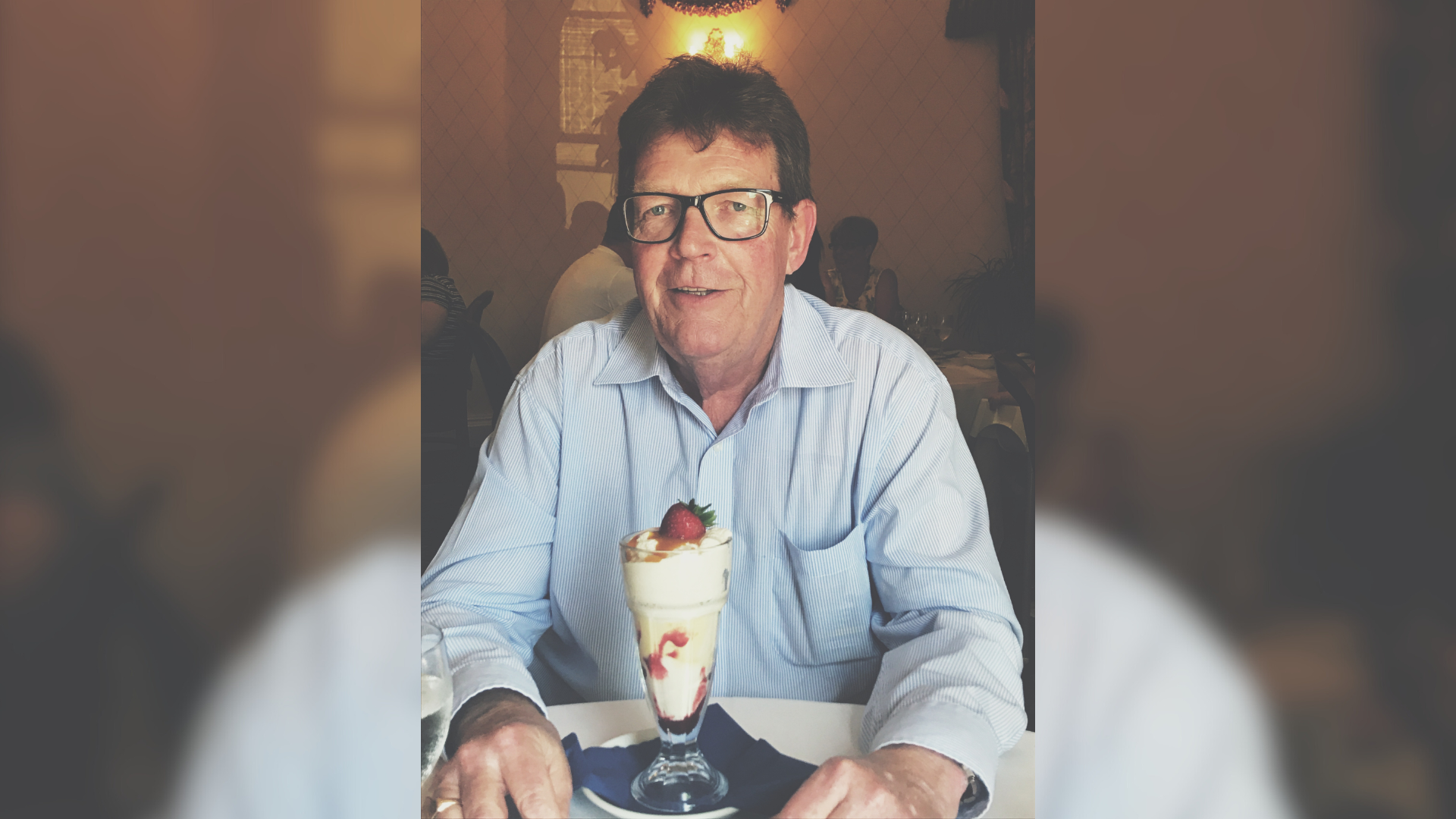 An old photo of a man sat with an ice cream sundae