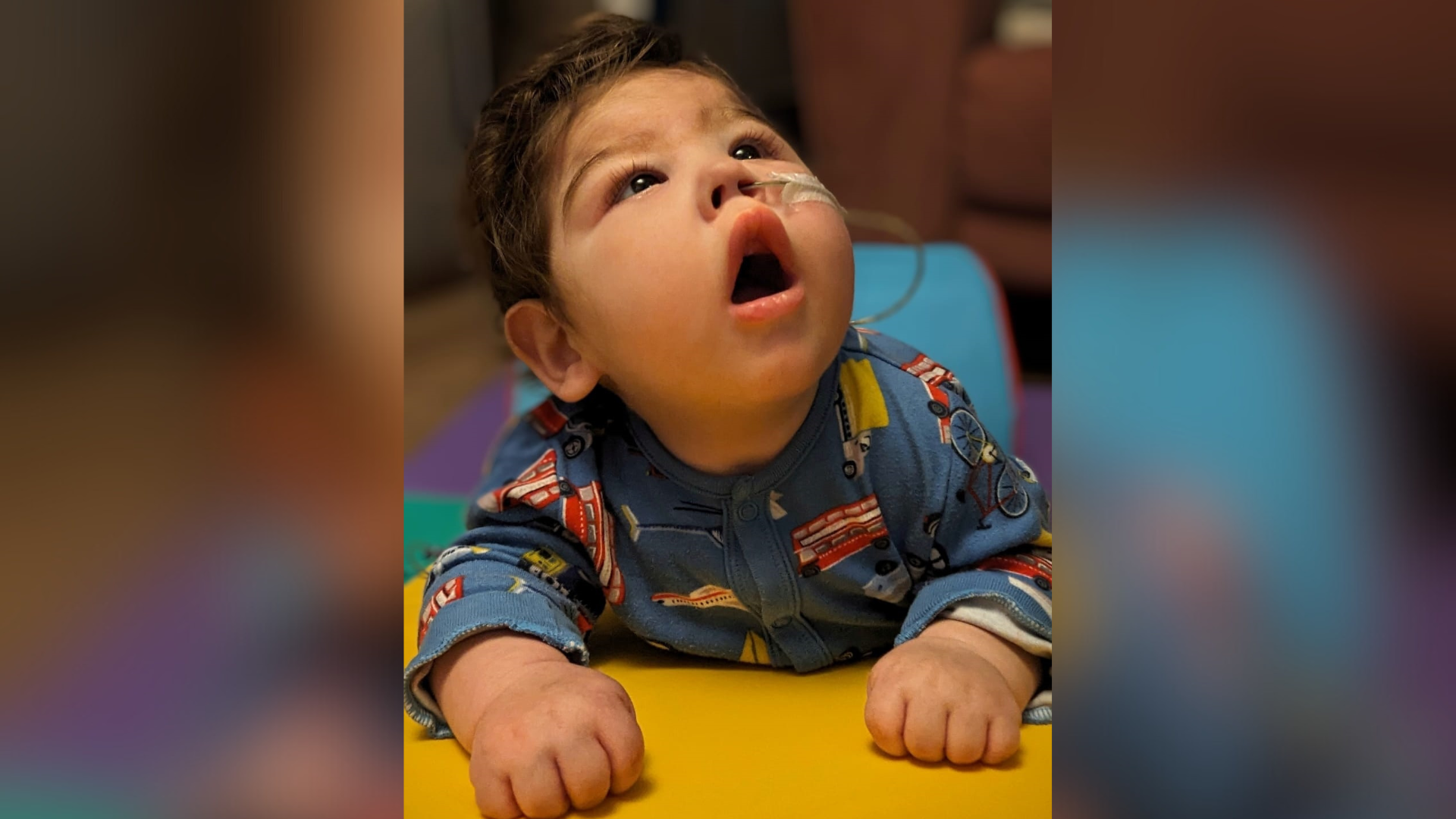 A toddler laying on the floor and looking up