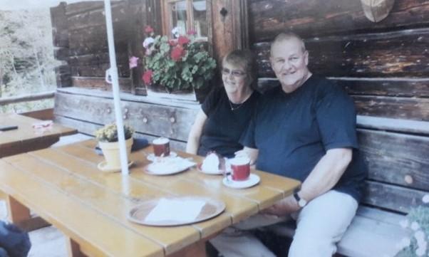 A couple sitting together at an outdoor restaurant table