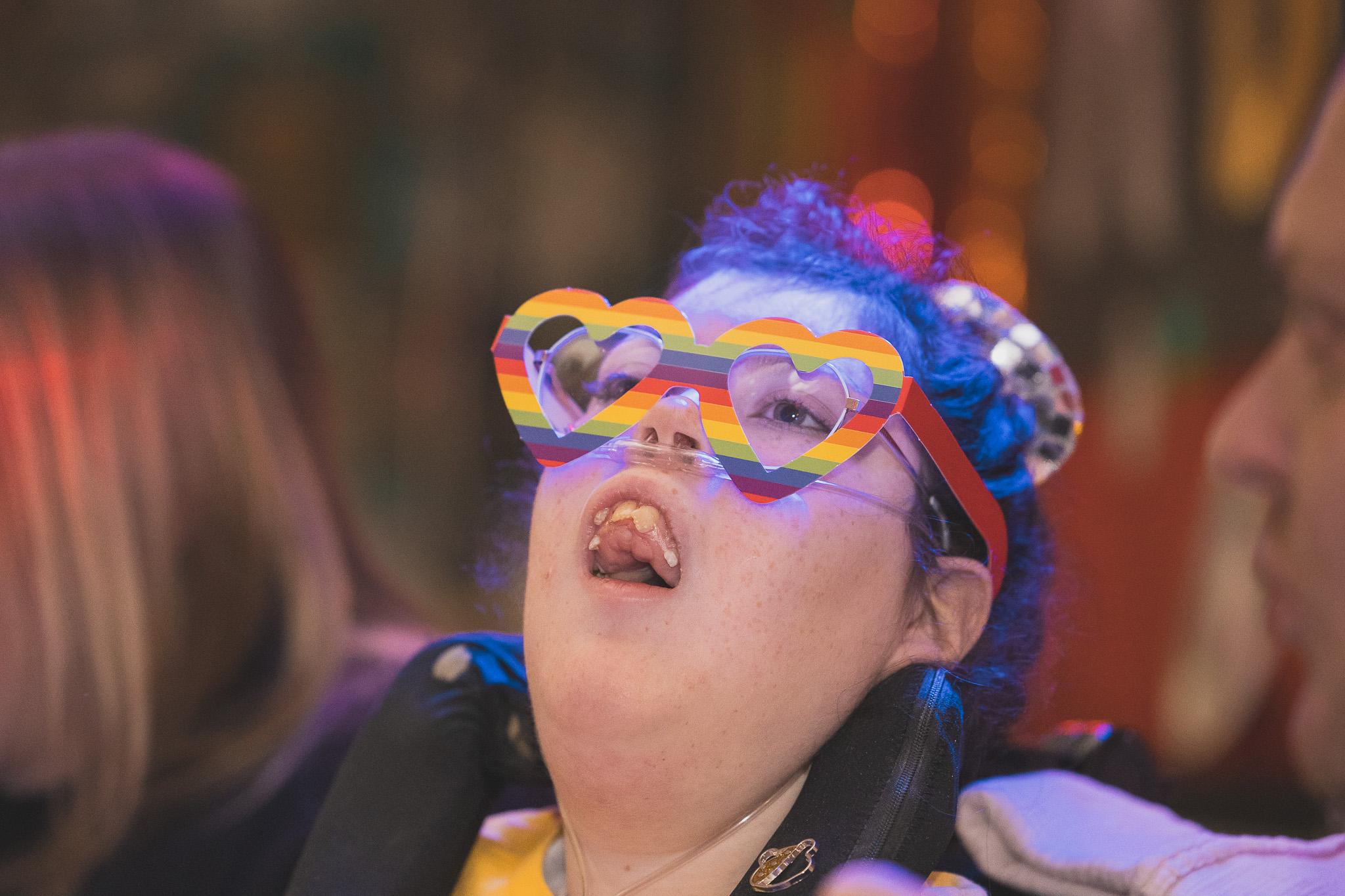 Young hospice patient wearing multicoloured heart-shaped glasses