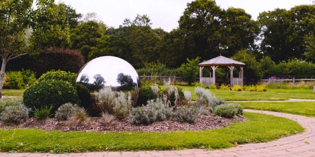 A garden featuring a globe shape water feature