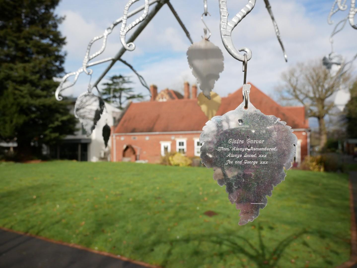 A silver engraved charm on a memory tree