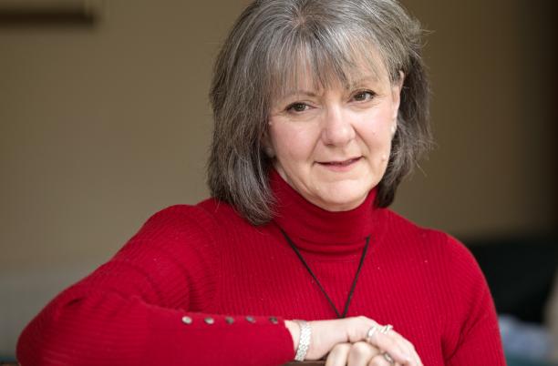 Carole Walford in red jumper, landscape headshot