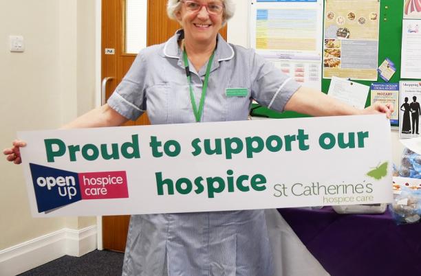 3 decades of hospice care, Bernadette Baxter holding a banner