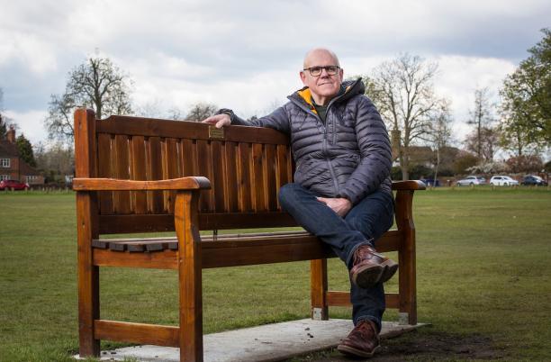 David sitting on a bench dedicated to his father