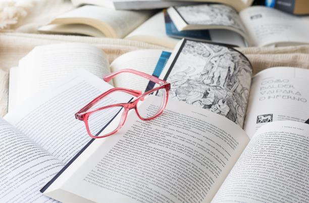 A stock image of a pair of glasses resting on a number of books