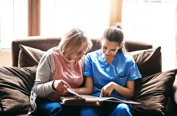 Nurse looks through photo album with patient