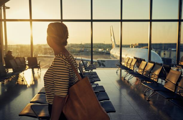 Woman walking through airport looking through window