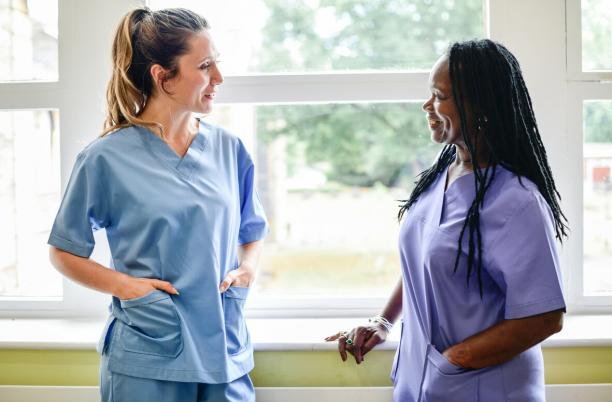two nurses talking in a hospital hallway