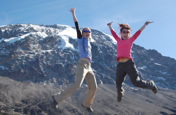 walkers jumping with joy in front on Kilimanjaro
